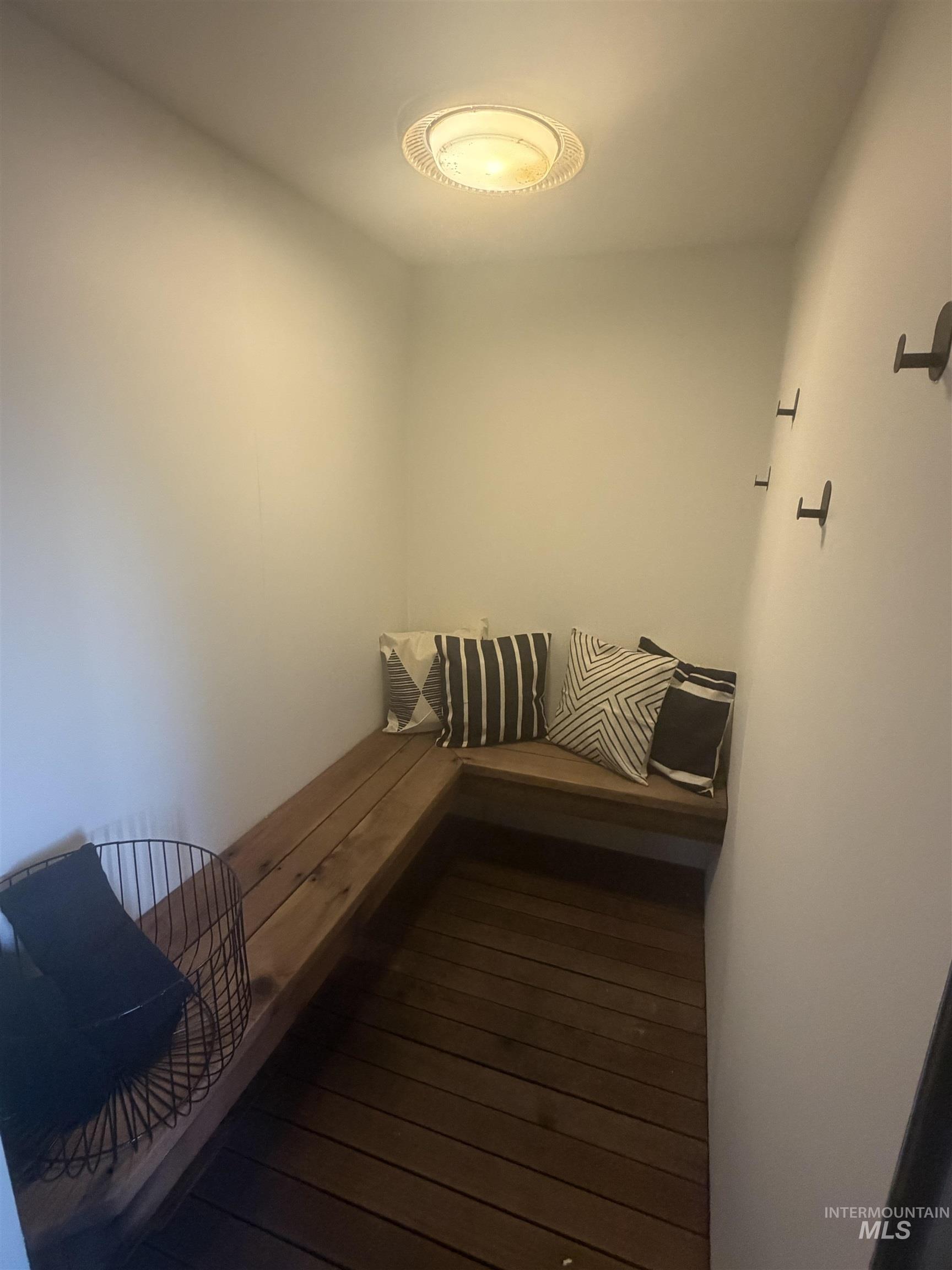 880 Jenkins Creek Road Weiser, ID 83672 - Photo 36 of 43 Built-in L-shaped bench seating with wood-finish planks, dark wood-finish flooring, and wall-mounted hooks