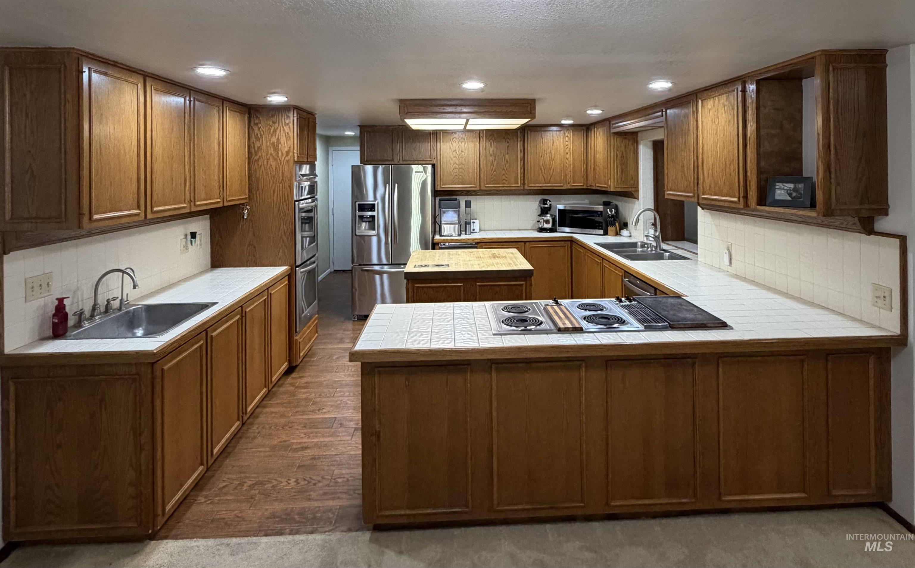 880 Jenkins Creek Road Weiser, ID 83672 - Photo 5 of 43 Kitchen featuring ample wood cabinetry, white tile countertops, and integrated stainless steel appliances