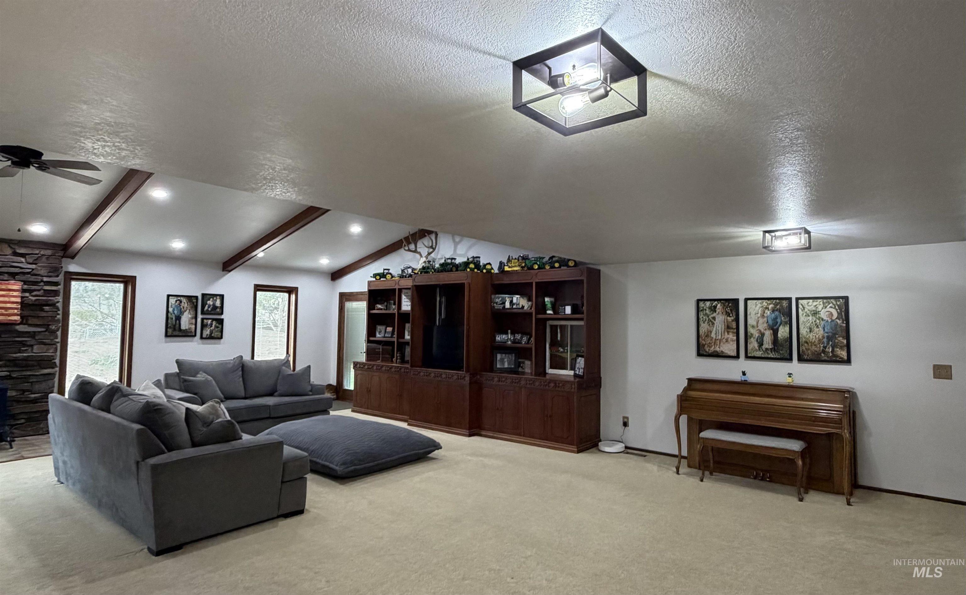 880 Jenkins Creek Road Weiser, ID 83672 - Photo 7 of 43 Spacious living area featuring a vaulted ceiling with exposed wood beams, recessed lighting, and a stone fireplace