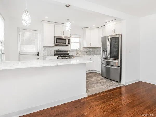 a kitchen with stainless steel appliances a refrigerator sink and microwave