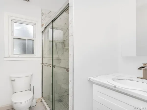 a bathroom with a toilet a sink and shower