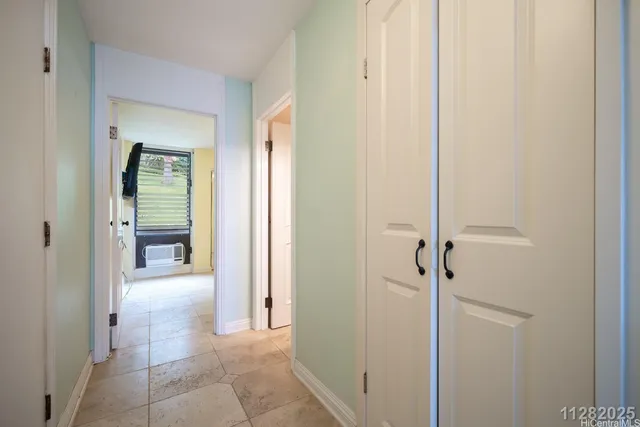 a view of a hallway with wooden floor and a bathroom