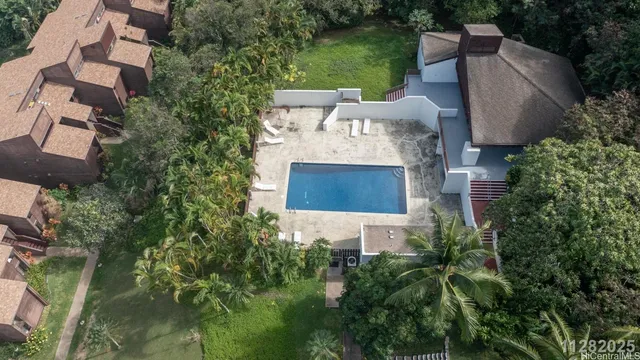 an aerial view of residential house with outdoor space and trees all around