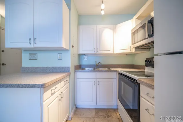 a kitchen with cabinets appliances and a window