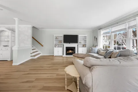 a living room with furniture a fireplace and a large window