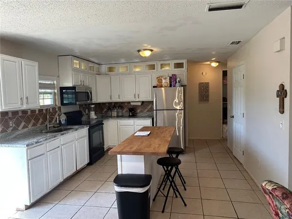 a kitchen with refrigerator and cabinets