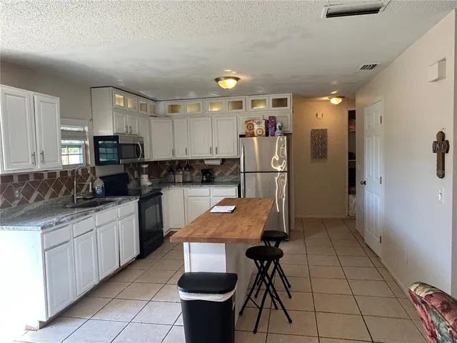 a kitchen with refrigerator and cabinets
