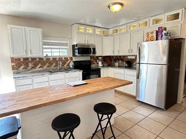 a kitchen with a refrigerator a stove a sink and a counter space