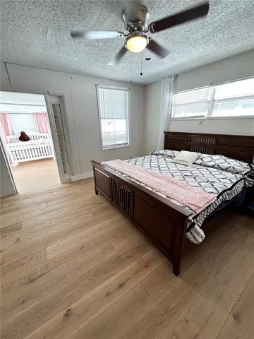 a bed sitting in a spacious bedroom next to a window