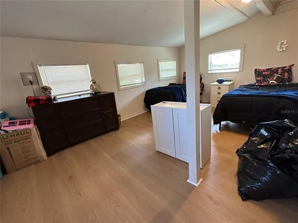 a bedroom with a bed and wooden floor