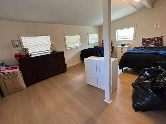 a bedroom with a bed and wooden floor