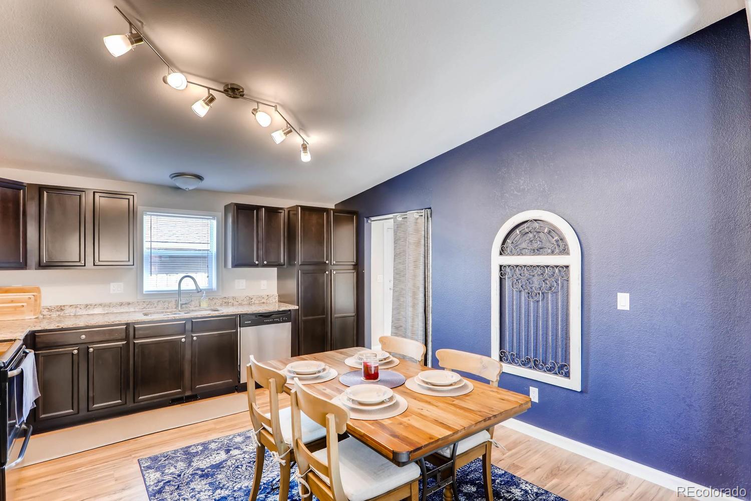 520 South Raleigh Street Denver, CO 80219 - Photo 12 of 27 a kitchen with stainless steel appliances granite countertop a dining table and chairs with wooden floor