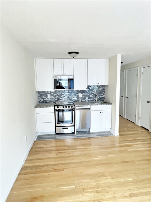 1039 Commonwealth Avenue, Unit 34 Boston, MA 02215 - Photo 2 of 6 a kitchen with stainless steel appliances granite countertop a stove a sink and white cabinets