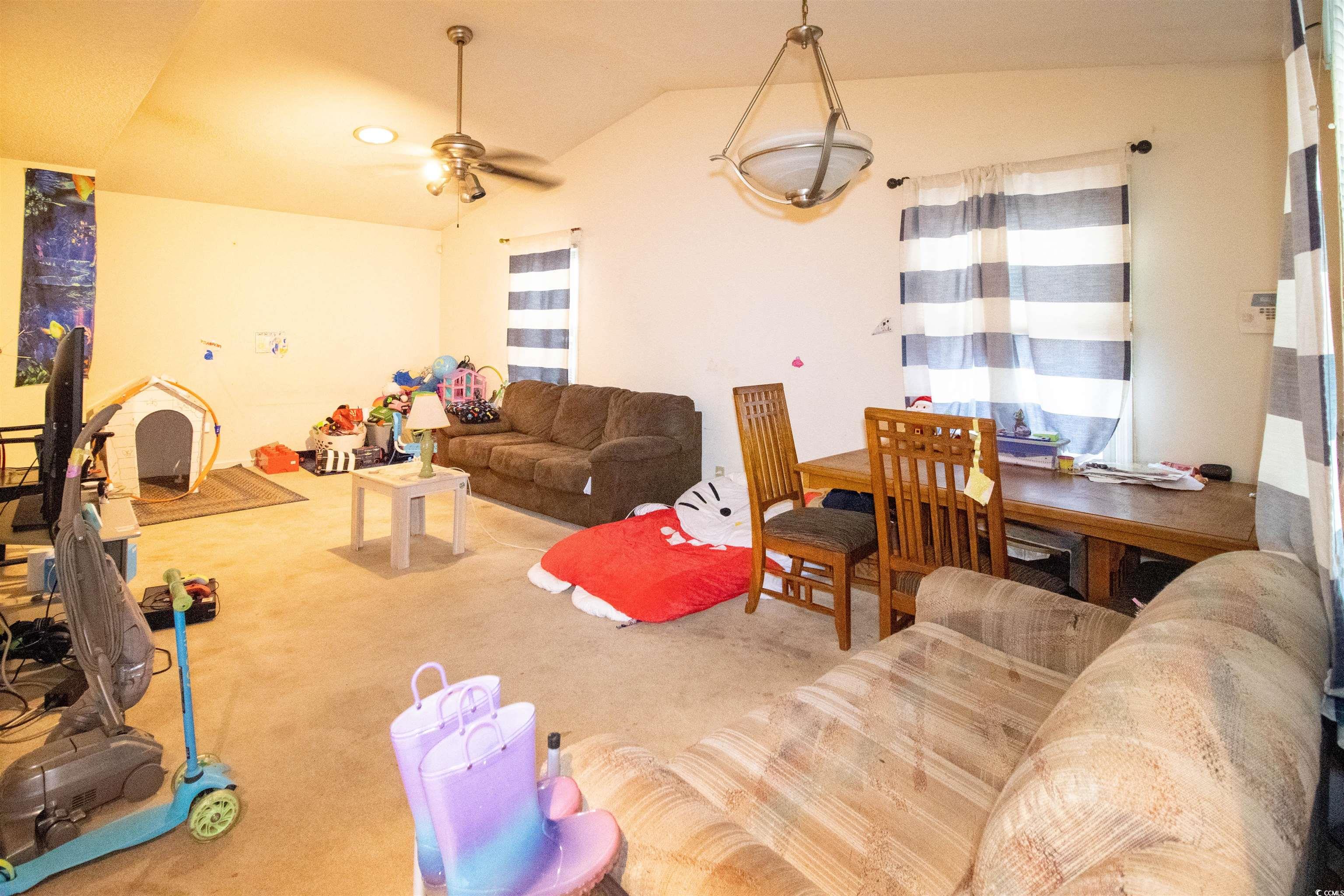 41 Channing Drive Little River, SC 29566 - Photo 6 of 19 Carpeted living area with ceiling fan and vaulted ceiling