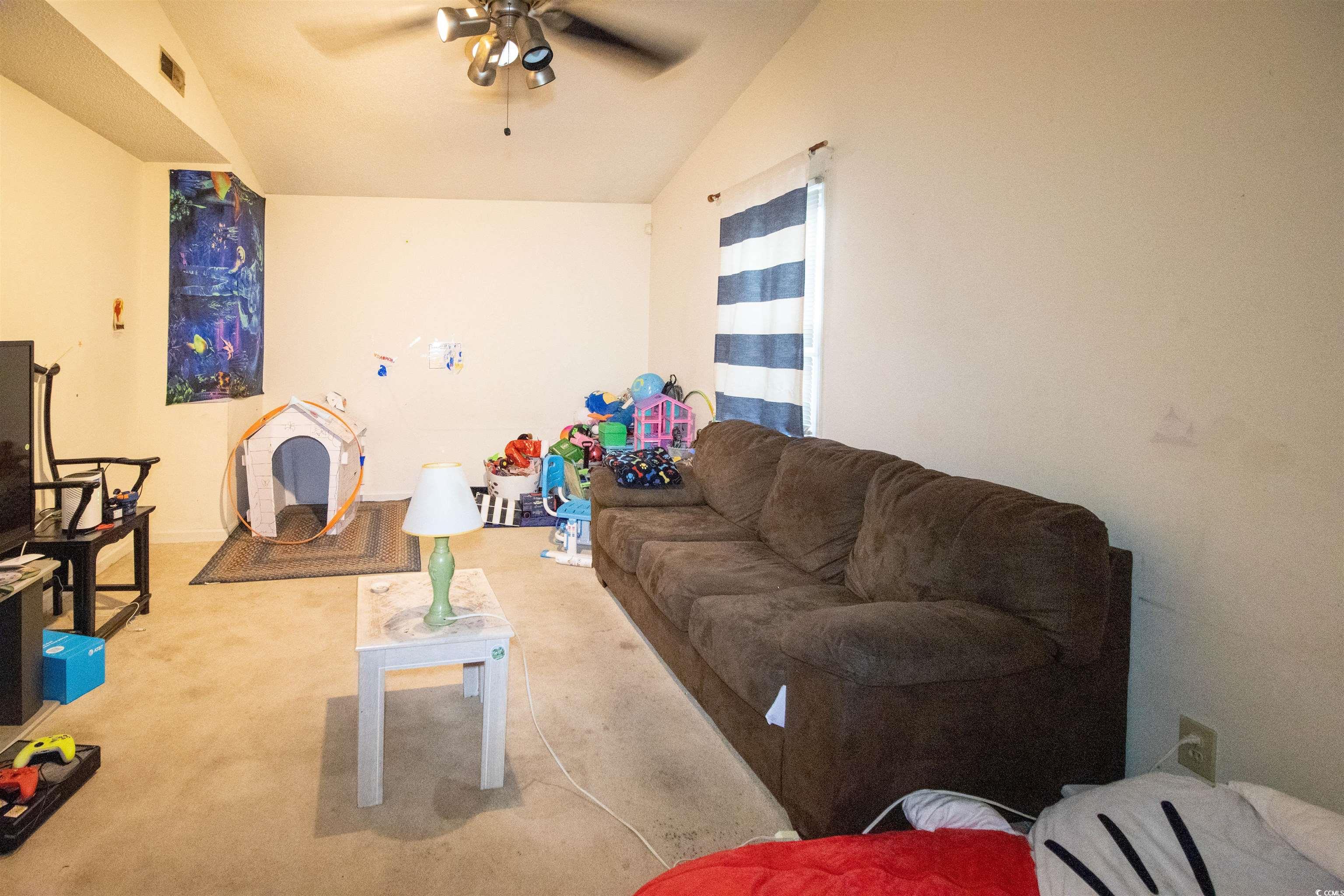 41 Channing Drive Little River, SC 29566 - Photo 7 of 19 Living room featuring carpet flooring, a ceiling fan, and lofted ceiling