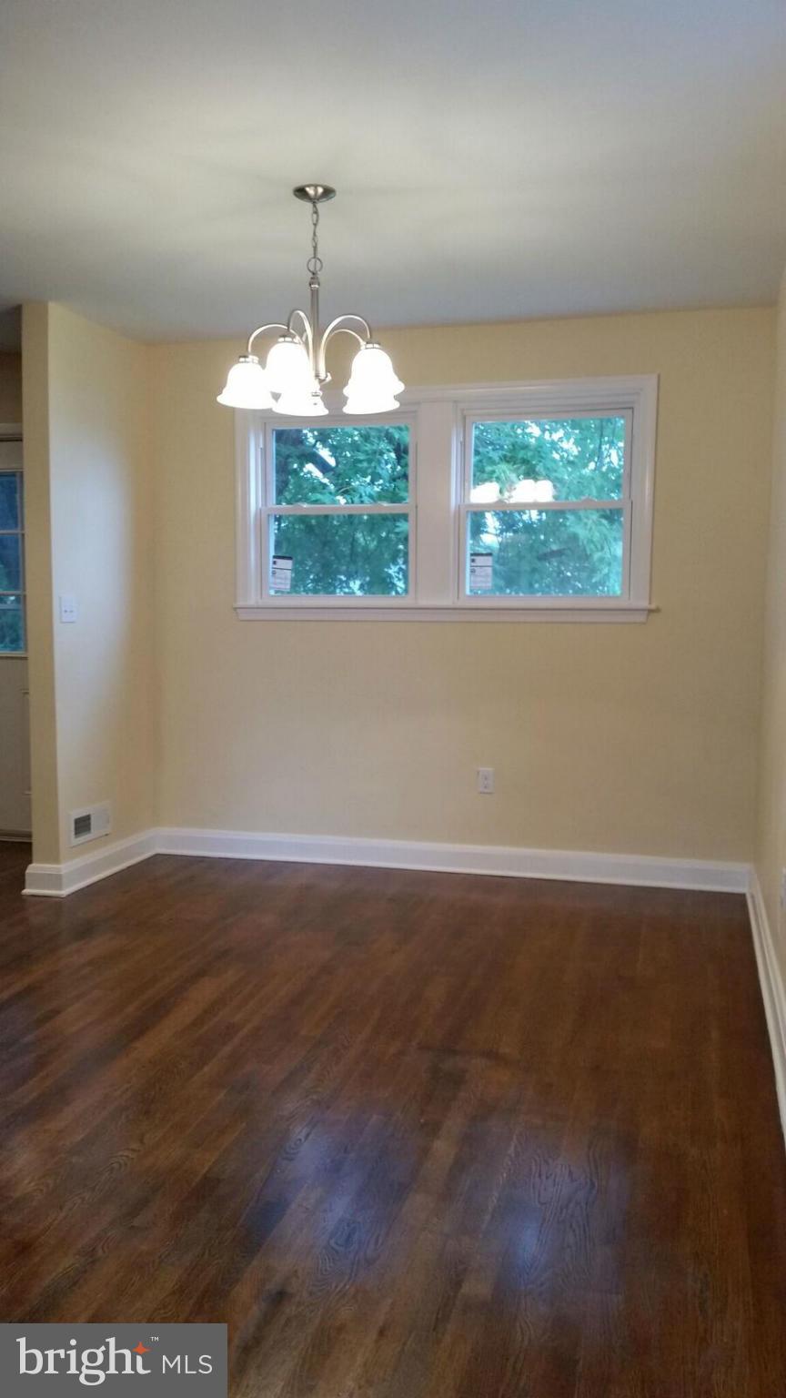 4845 Greencrest Road Baltimore, MD 21206 - Photo 11 of 28 an empty room with wooden floor and windows