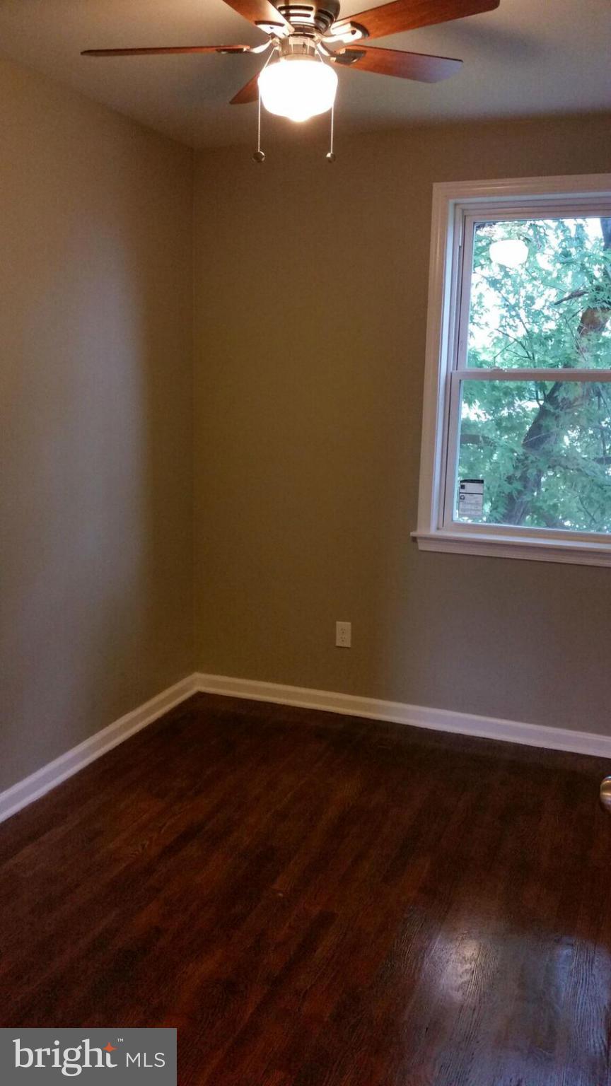4845 Greencrest Road Baltimore, MD 21206 - Photo 12 of 28 a view of an empty room with wooden floor and a window
