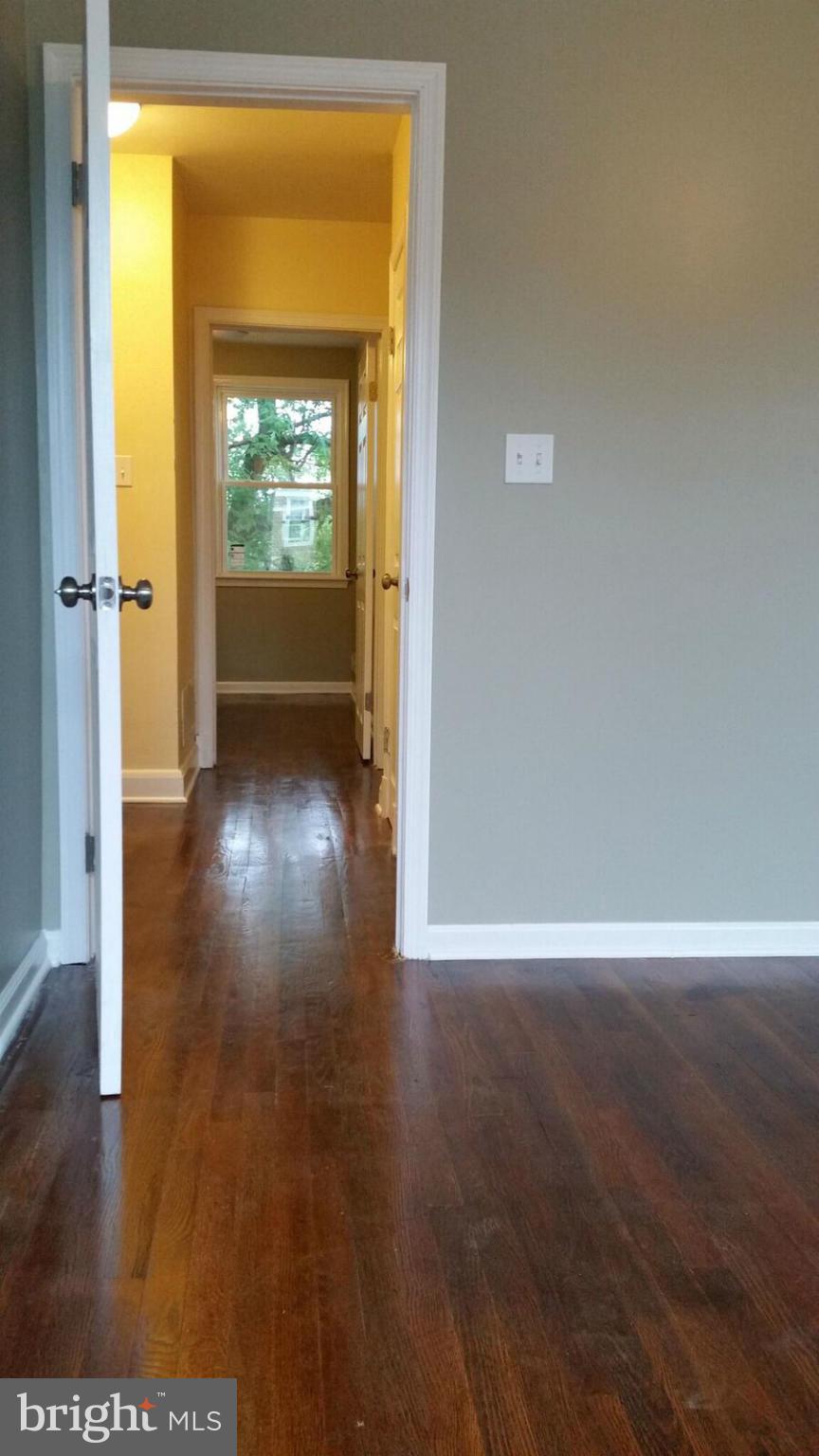 4845 Greencrest Road Baltimore, MD 21206 - Photo 17 of 28 a view of a hallway with wooden floor and a bathroom