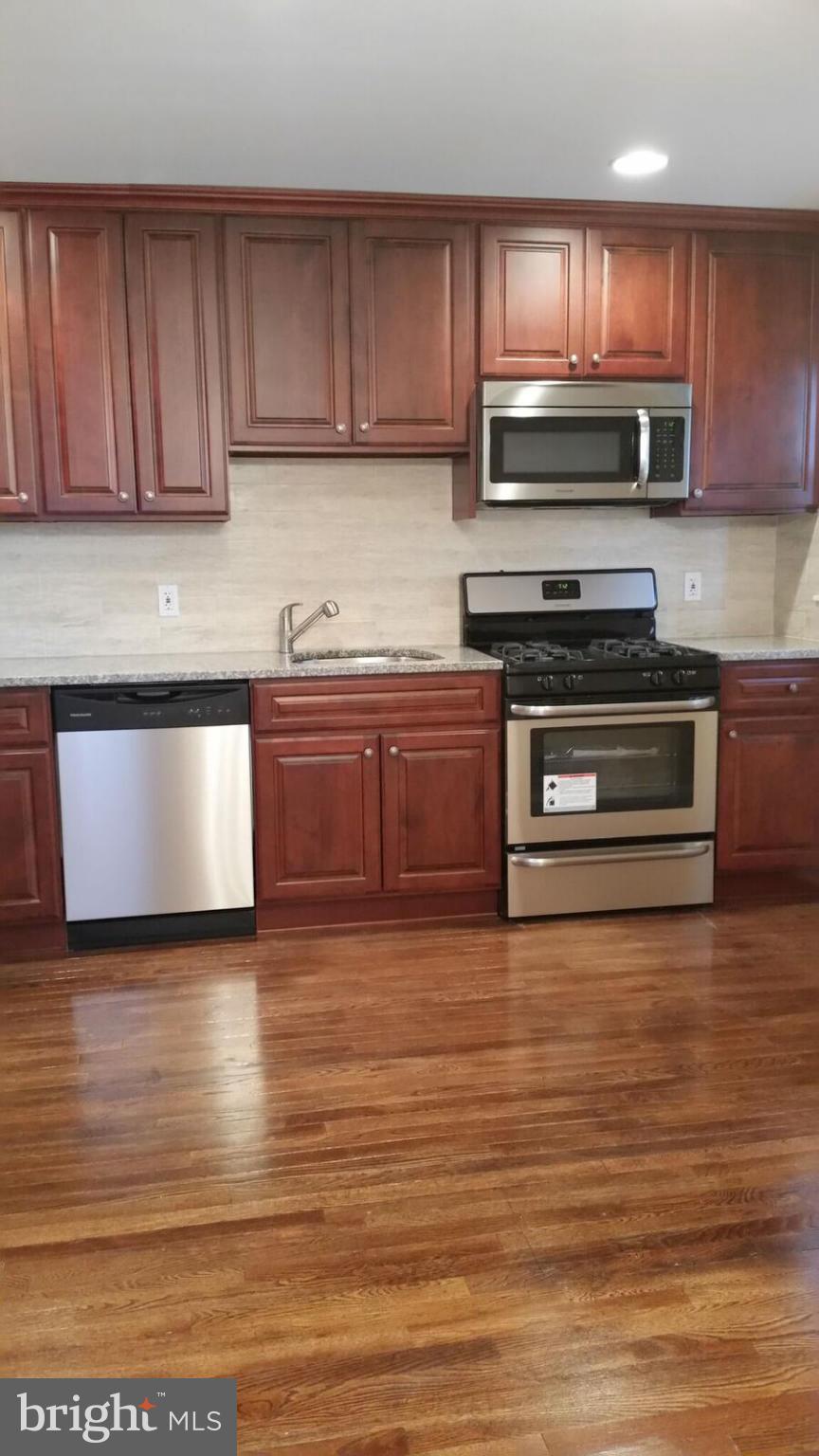 4845 Greencrest Road Baltimore, MD 21206 - Photo 7 of 28 a kitchen with stainless steel appliances granite countertop a stove a sink and a microwave