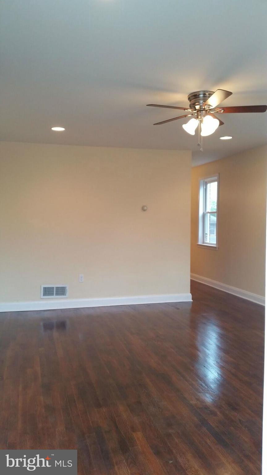 4845 Greencrest Road Baltimore, MD 21206 - Photo 10 of 28 a view of an empty room with window and wooden floor