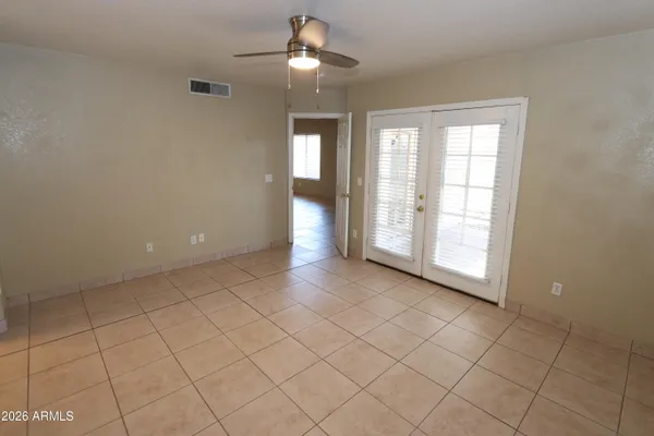 an empty room with chandelier fan