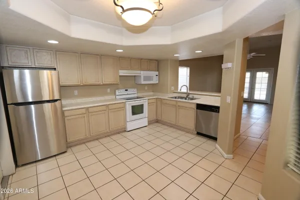 a kitchen with white cabinets a sink dishwasher and a refrigerator