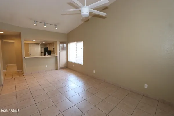 an empty room with windows and ceiling fan