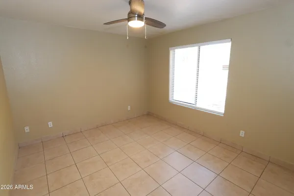 an empty room with windows and fan