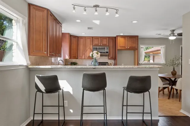 a kitchen with stainless steel appliances kitchen island granite top and furniture