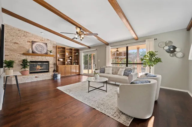 a living room with furniture a fireplace and a large window