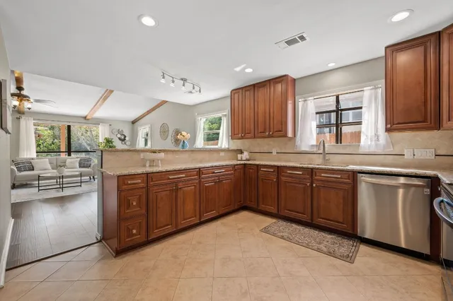 a kitchen with stainless steel appliances granite countertop a sink counter space cabinets and a large window