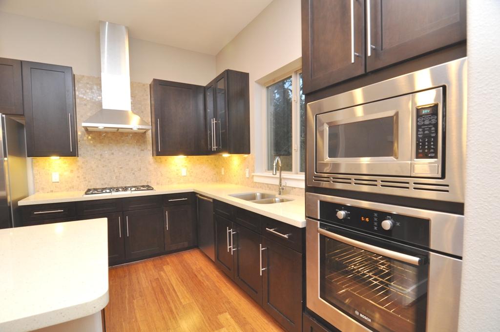 4303 Dickson Street, Unit A Houston, TX 77007 - Photo 4 of 30 a kitchen with granite countertop a stove and cabinets