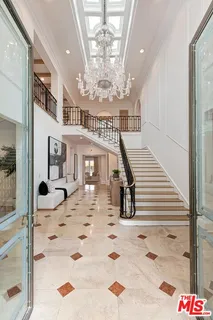 a view of a hallway with a chandelier and living room view