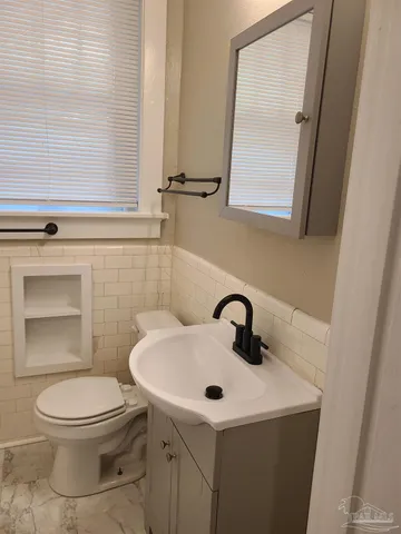 a bathroom with a toilet sink and mirror