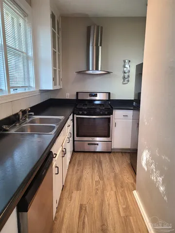 a kitchen with granite countertop a sink and a stove top oven