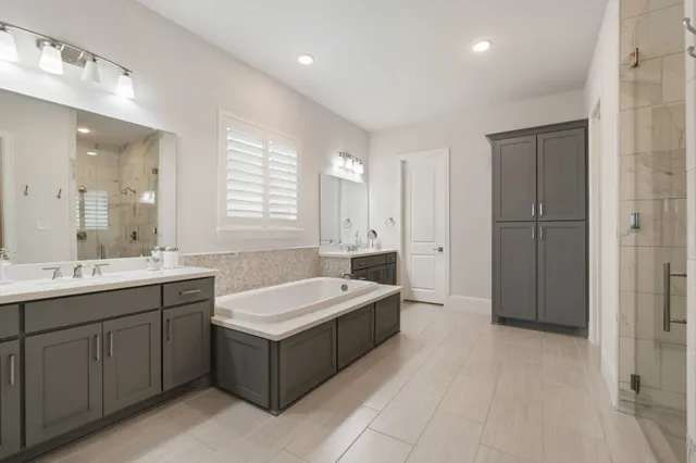 a spacious bathroom with a sink tub and a mirror
