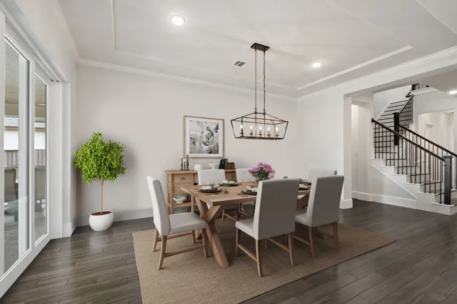 a large kitchen with granite countertop a large island a sink dishwasher a dining table chairs and wooden floor