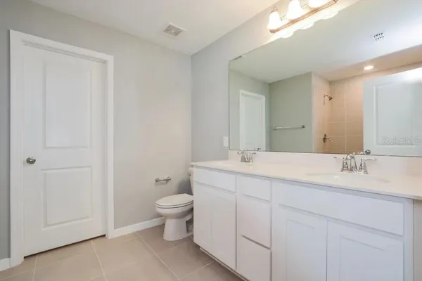 a bathroom with a toilet a sink and mirror