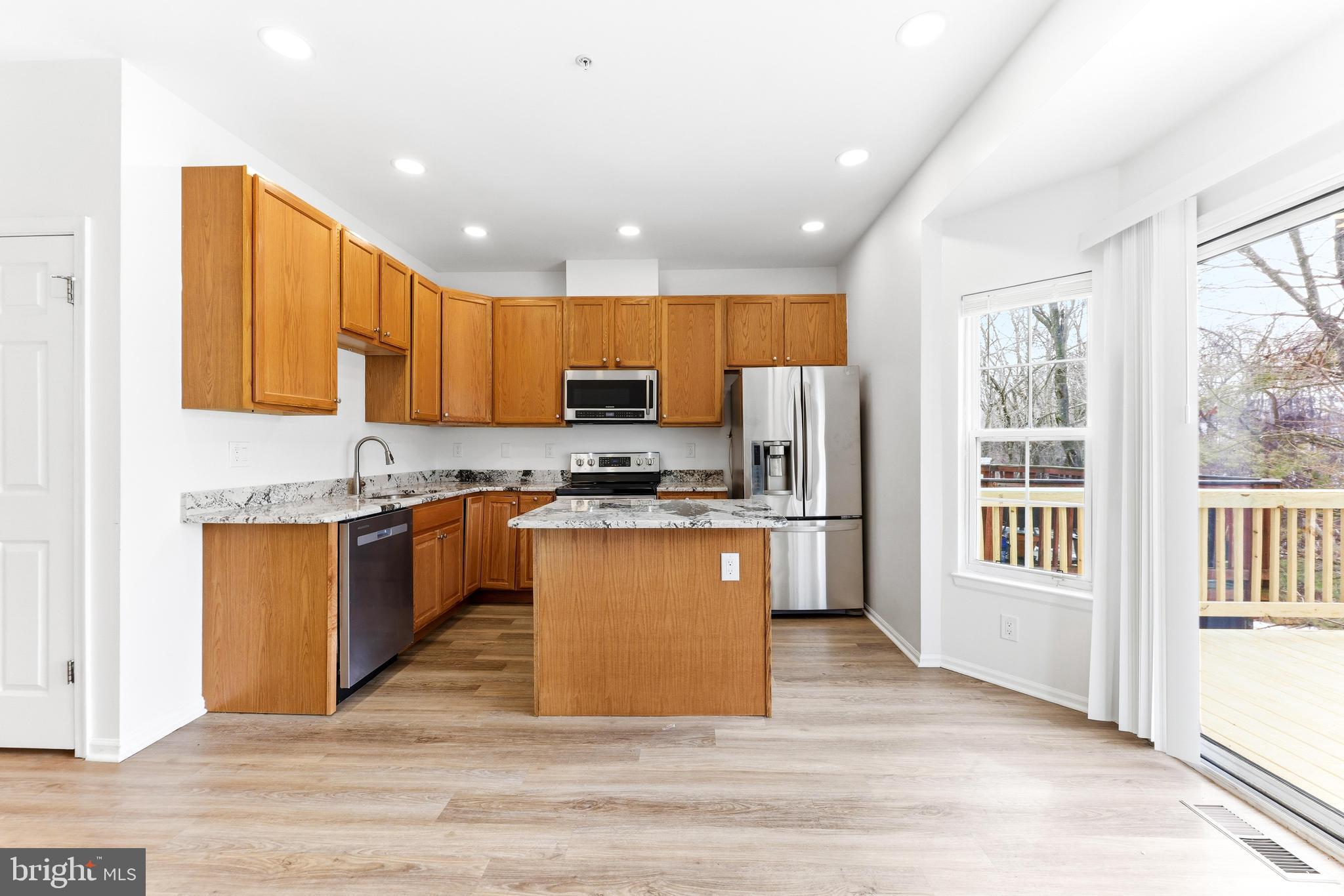 8428 Gold Sunset Way Columbia, MD 21045 - Photo 11 of 43 a kitchen with stainless steel appliances granite countertop a refrigerator stove top oven and sink