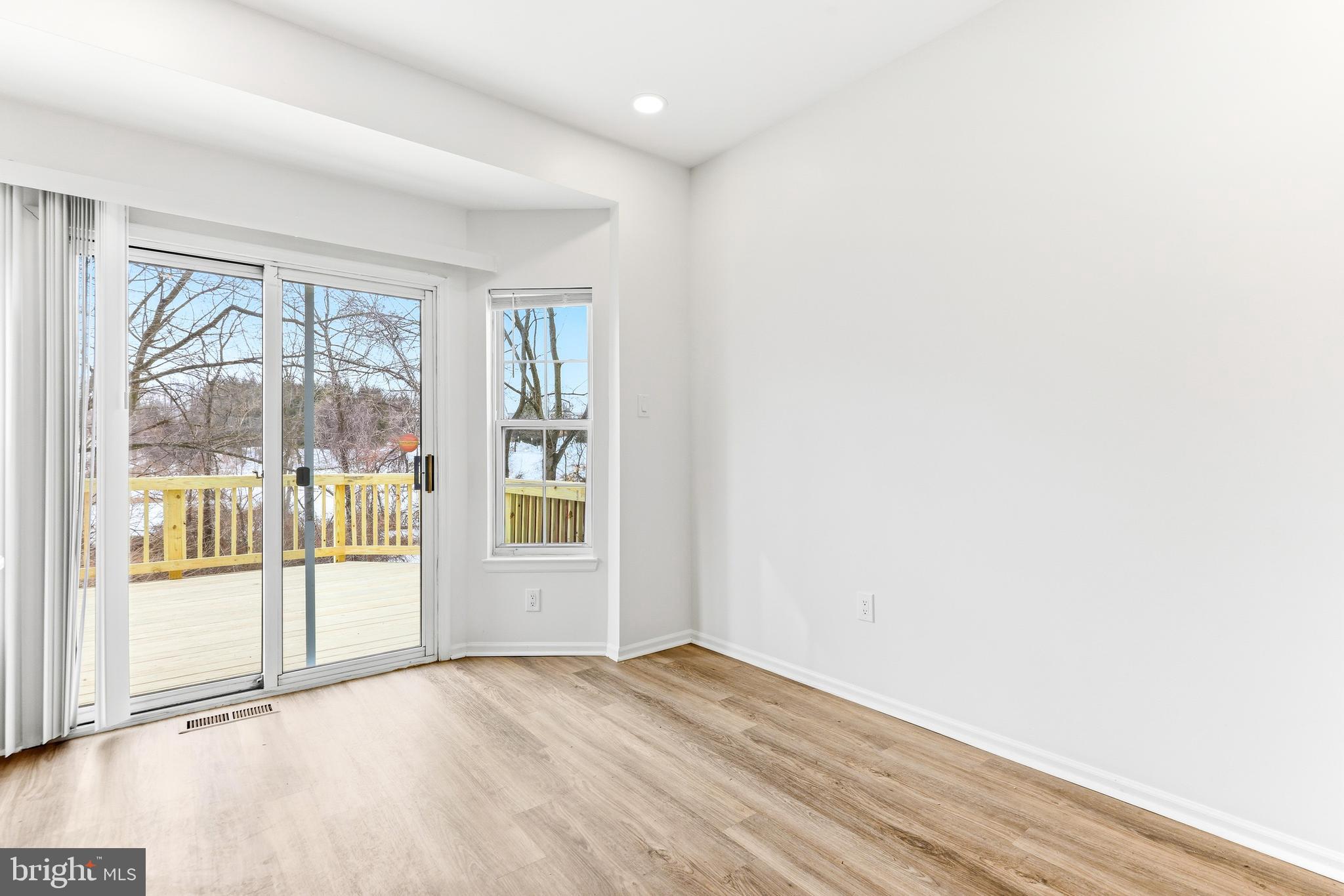 8428 Gold Sunset Way Columbia, MD 21045 - Photo 14 of 43 a view of an empty room with wooden floor and a window