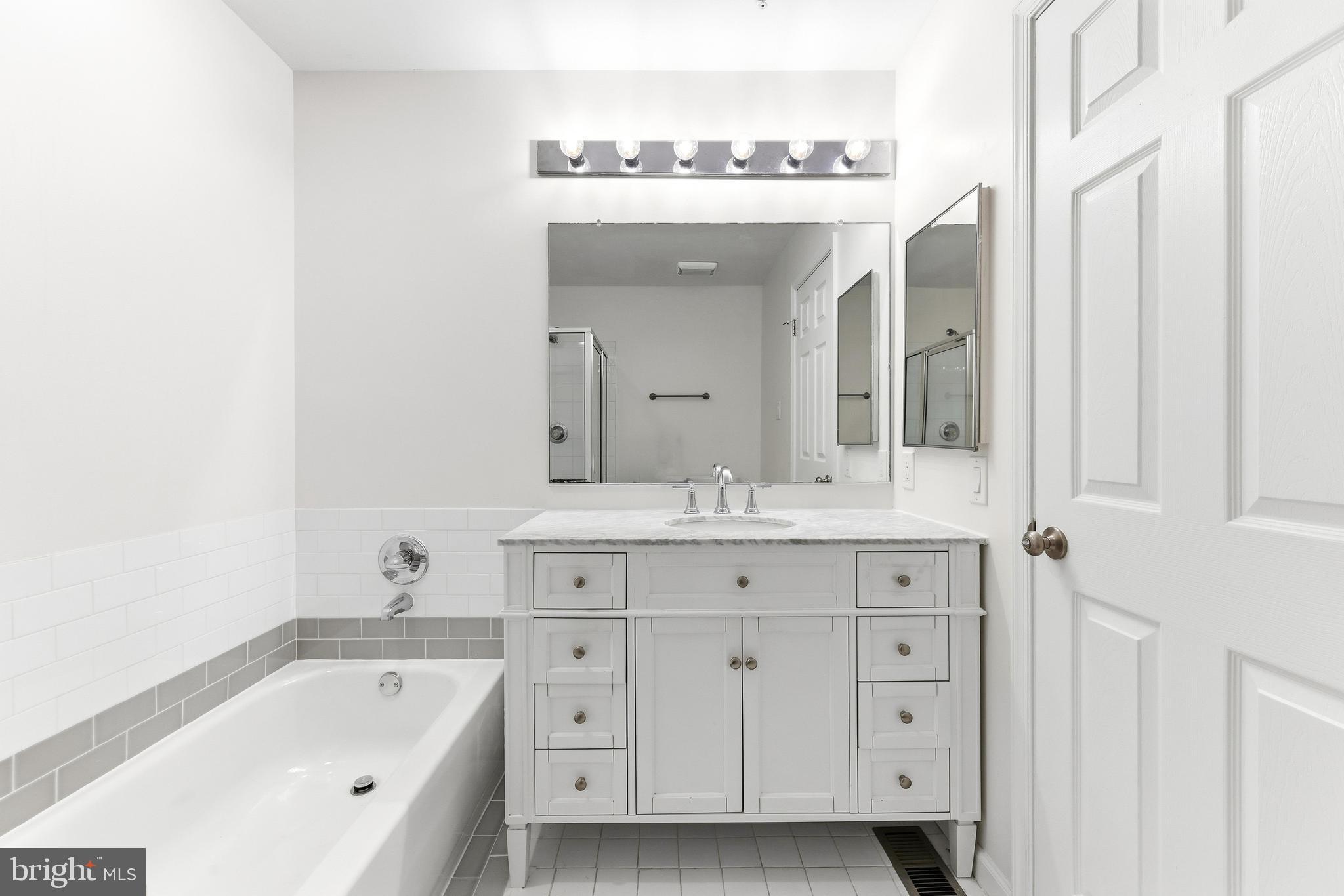 8428 Gold Sunset Way Columbia, MD 21045 - Photo 31 of 43 a spacious bathroom with a tub sink and mirror