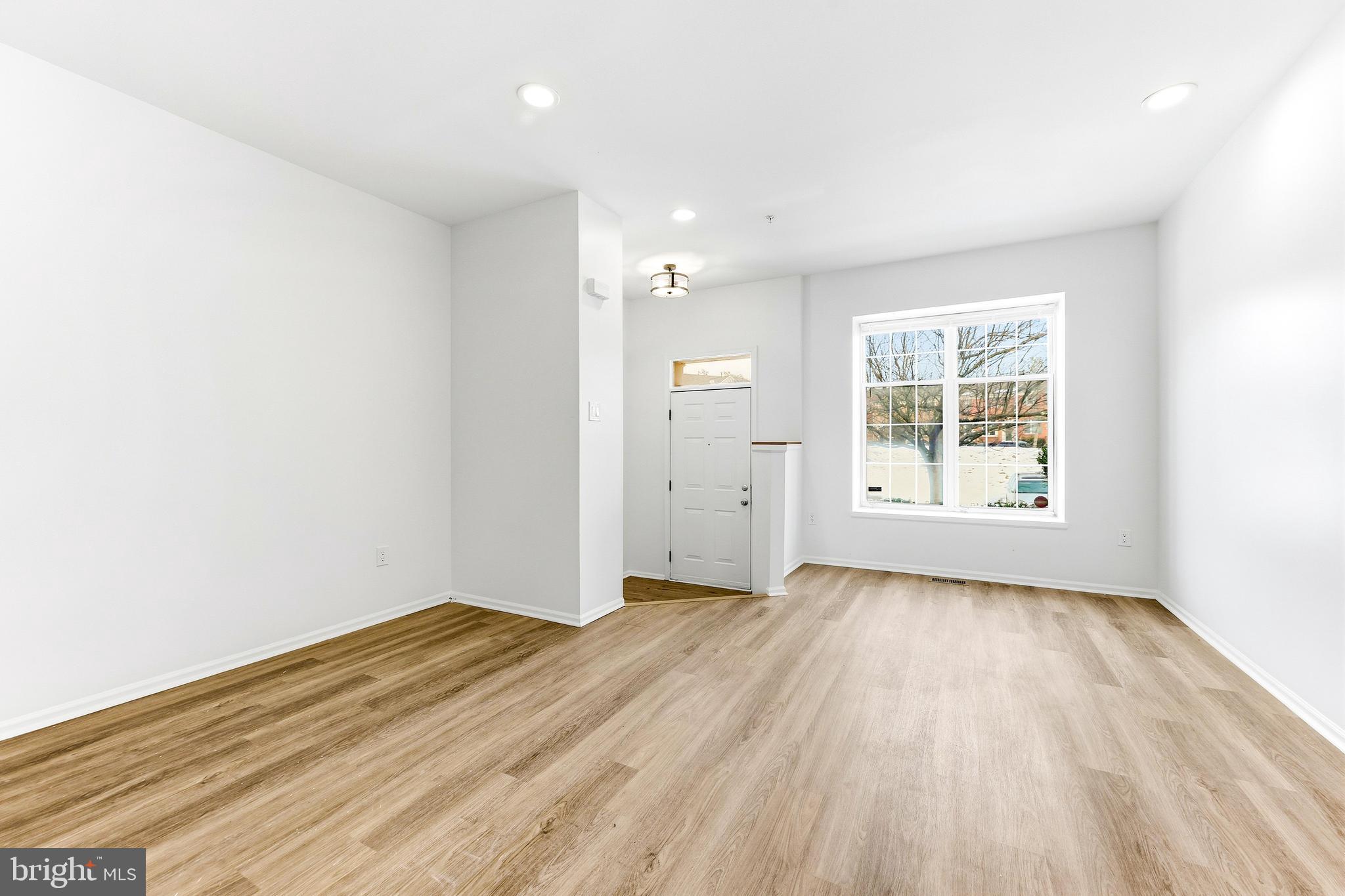 8428 Gold Sunset Way Columbia, MD 21045 - Photo 4 of 43 an empty room with wooden floor and windows