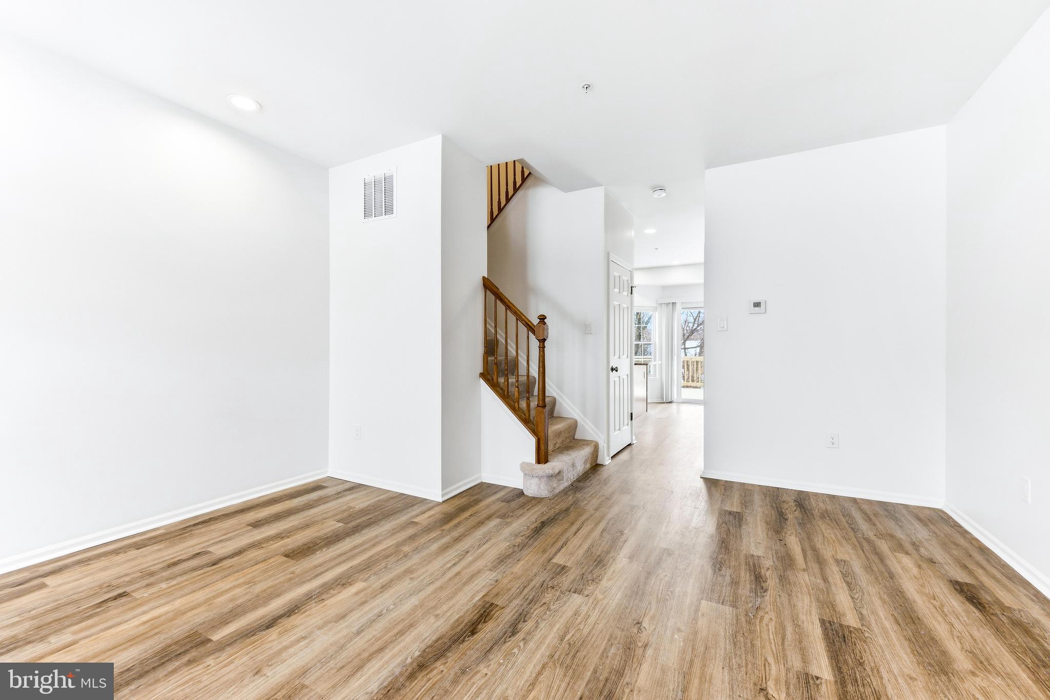 8428 Gold Sunset Way Columbia, MD 21045 - Photo 7 of 43 a view of a room with wooden floor and stairs