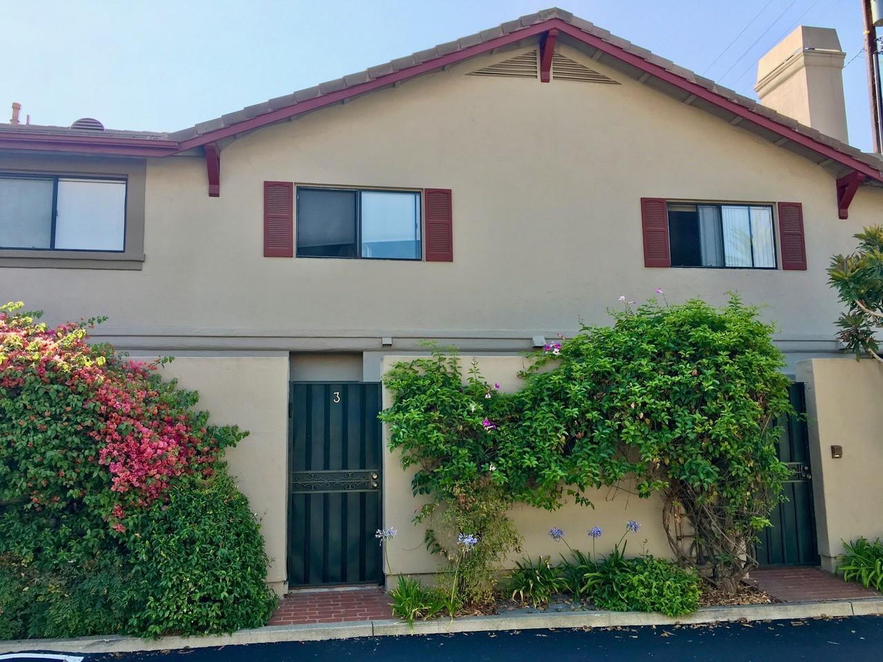 a front view of a house with plants