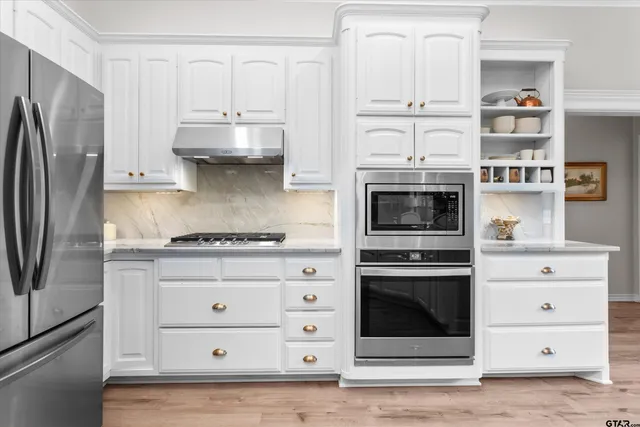 a kitchen with cabinets stainless steel appliances and a counter space