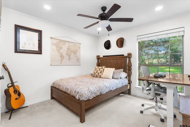 a bedroom with a bed a large window and a chandelier