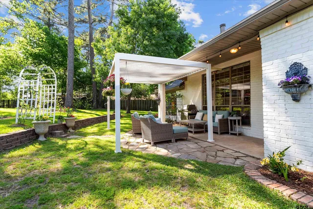 a view of a house with backyard and sitting area