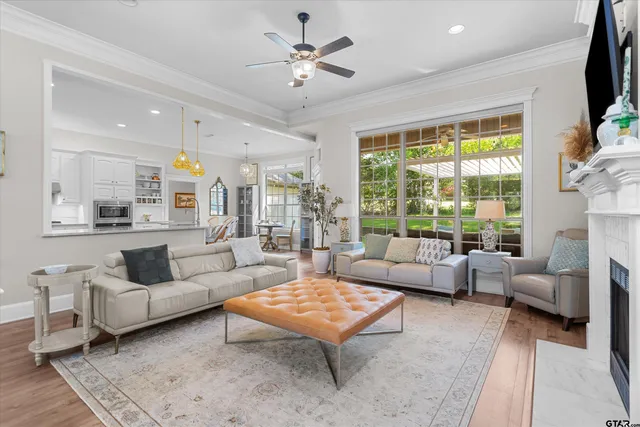 a living room with furniture flat screen tv and a large window