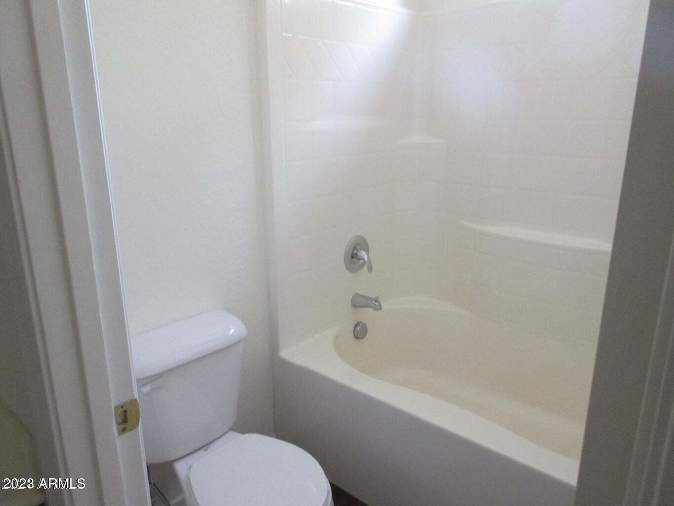 23742 West Hidalgo Avenue Buckeye, AZ 85326 - Photo 20 of 25 a white toilet sitting next to a bath tub