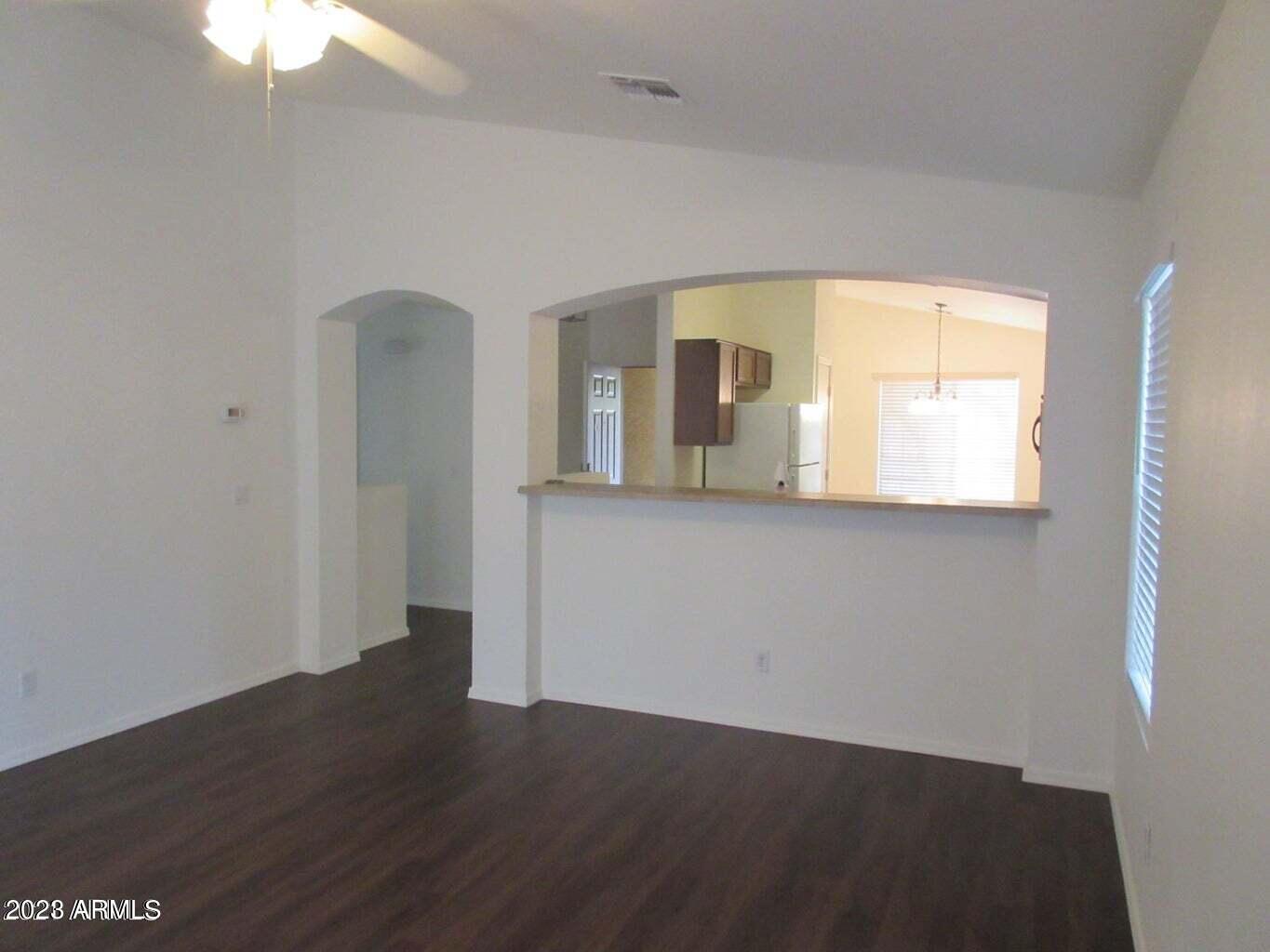 23742 West Hidalgo Avenue Buckeye, AZ 85326 - Photo 5 of 25 an empty room with wooden floor and windows